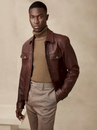 Une veste en cuir souple et marron complète la nature élégante du pull à col roulé.