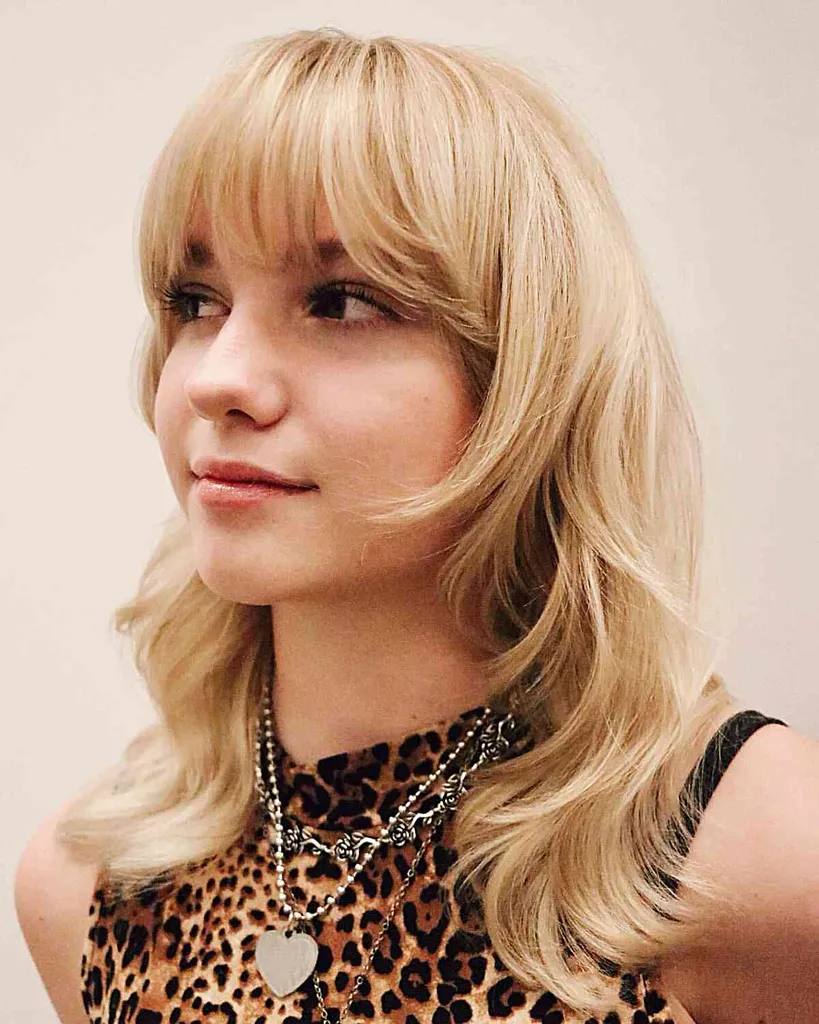 ミディアムヘアの女性向けの前髪ありのソフトブロンドウルフカット' title=