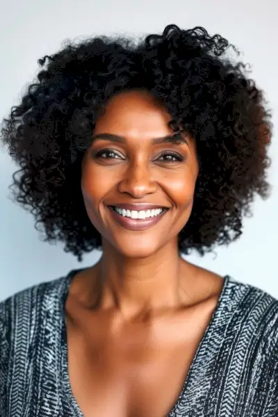 Acconciatura riccia con riccioli corti e stretti per donne sopra i 50 anni.