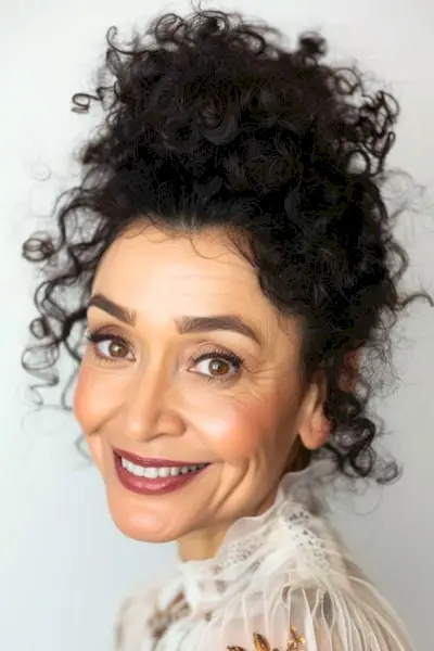 Acconciatura riccia riccia updo per donne sopra i 50 anni.