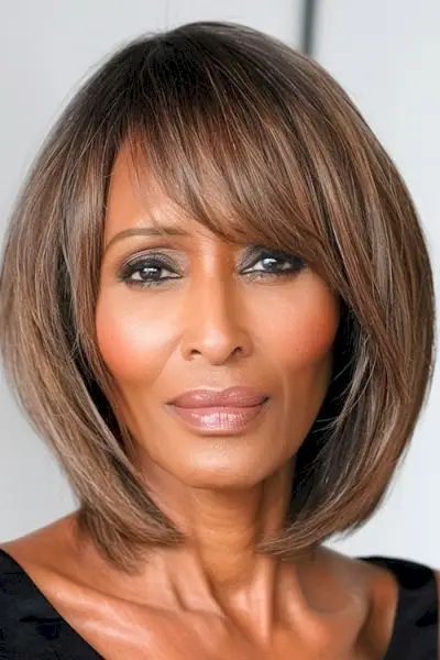 60세 이상 여성을 위한 앞머리 헤어스타일이 있는 매끄러운 갈색 스트레이트 보브.