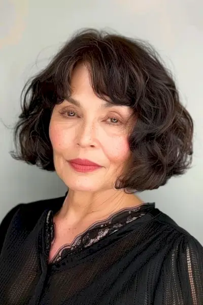 60세 이상의 여성을 위한 앞머리가 있는 물결 모양의 짧은 갈색 보브.