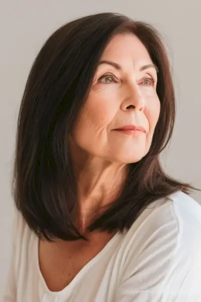 60歳以上の年配の女性のストレートの茶色のロブヘアカット。