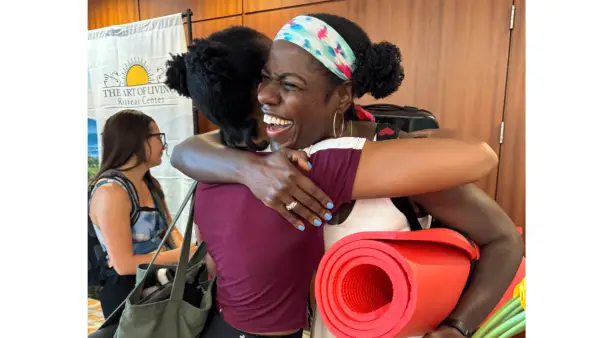 Women yoga students and teachers hugging at the Dirty South Yoga Fest.