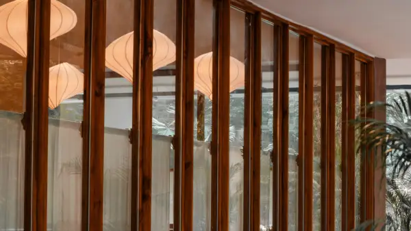a wall of wood-framed windows reflecting white light fixtures